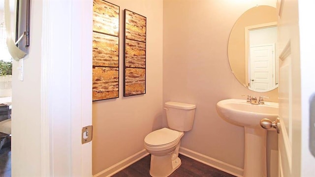 bathroom featuring hardwood / wood-style flooring and toilet