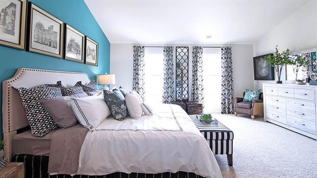 bedroom featuring carpet and vaulted ceiling