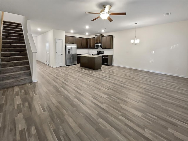 kitchen with ceiling fan, wood-type flooring, a kitchen island, stainless steel appliances, and hanging light fixtures