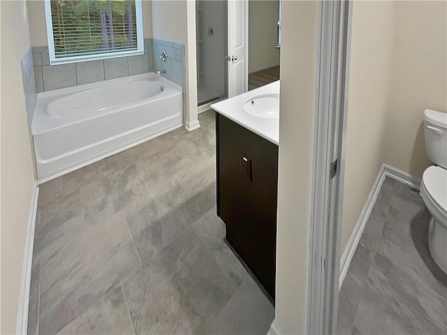 full bath featuring toilet, a garden tub, vanity, and baseboards