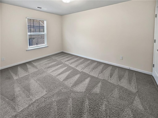 carpeted spare room featuring baseboards and visible vents