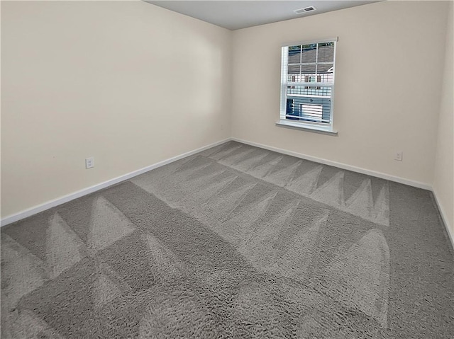 carpeted empty room featuring baseboards and visible vents