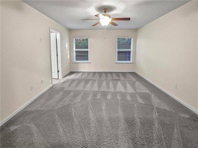 carpeted spare room featuring ceiling fan