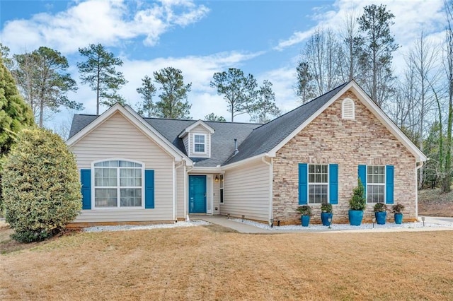 view of front of home featuring stone siding, a shingled roof, and a front lawn