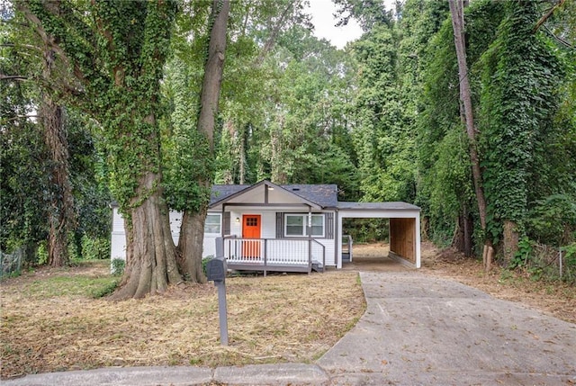 2437 Clarissa Dr NW, Atlanta, GA 30318 - view of front of property with driveway, a carport, covered porch, and a forest view