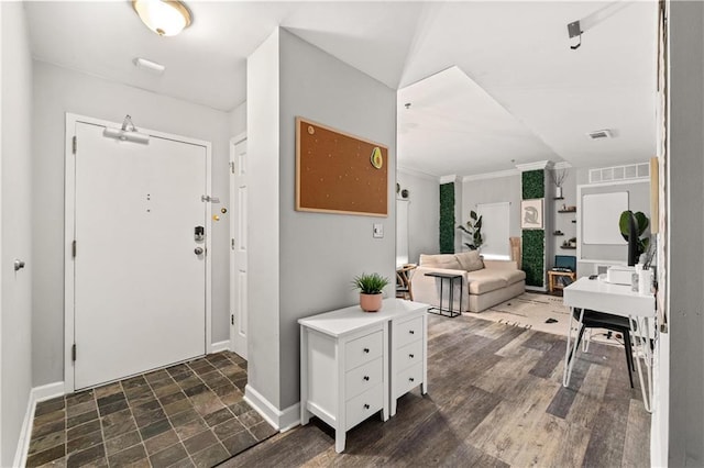 foyer entrance featuring ornamental molding and dark wood-type flooring