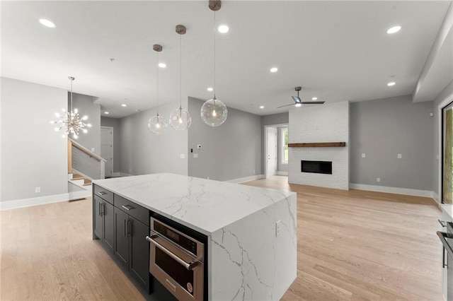 1420 Coretta Bnd, Atlanta, GA 30318 - kitchen with oven, a large fireplace, light wood-type flooring, a center island, and pendant lighting