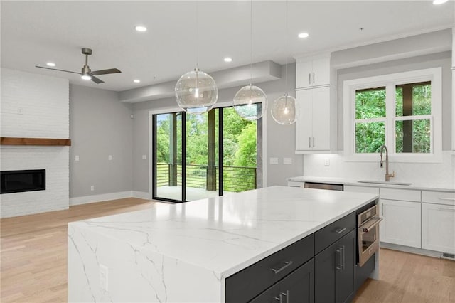 1420 Coretta Bnd, Atlanta, GA 30318 - kitchen with a sink, stainless steel appliances, a kitchen island, light wood-type flooring, and white cabinets
