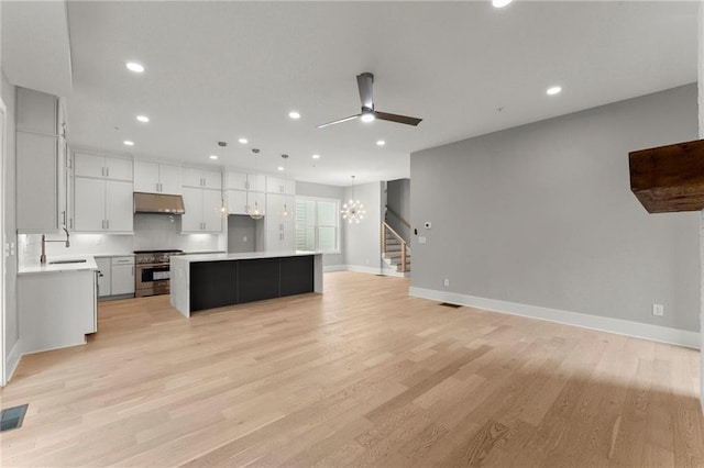 1420 Coretta Bnd, Atlanta, GA 30318 - kitchen with high end stainless steel range oven, under cabinet range hood, a chandelier, a kitchen island, and light countertops