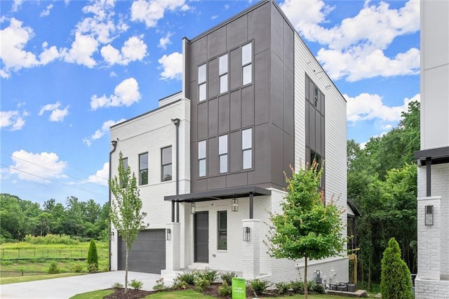 1420 Coretta Bnd, Atlanta, GA 30318 - view of front facade featuring an attached garage, driveway, brick siding, and board and batten siding