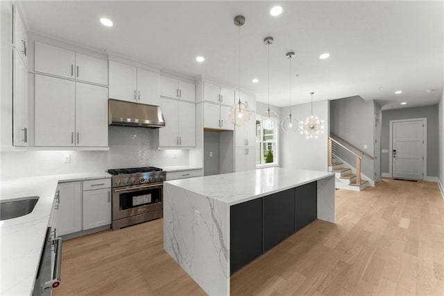 1420 Coretta Bnd, Atlanta, GA 30318 - kitchen featuring high end stove, under cabinet range hood, a kitchen island, recessed lighting, and light wood-style flooring