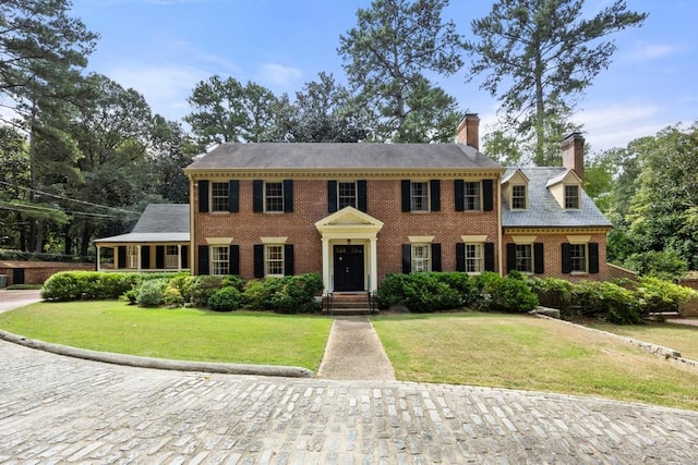 colonial inspired home with a front lawn