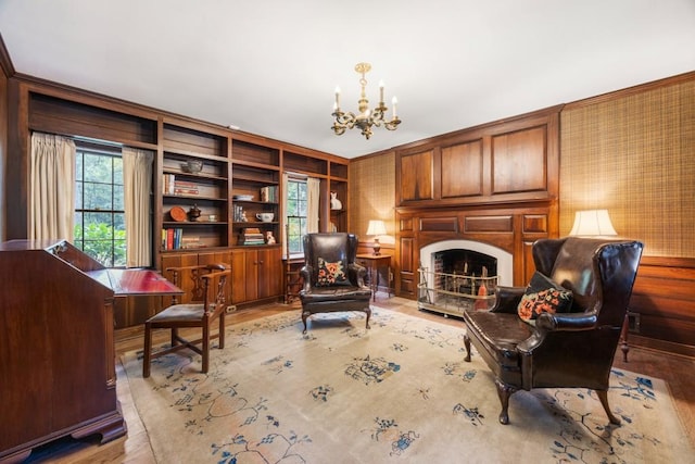 sitting room featuring built in features, an inviting chandelier, and wooden walls