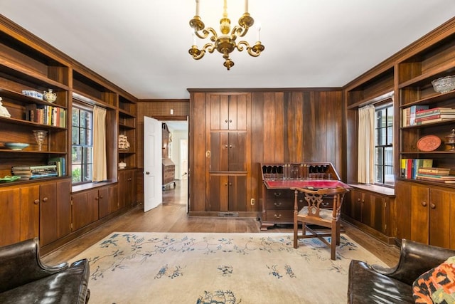 office space featuring a wealth of natural light, wood walls, light hardwood / wood-style flooring, and crown molding