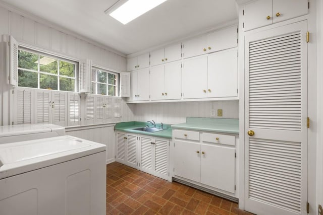 washroom featuring cabinets, sink, and independent washer and dryer