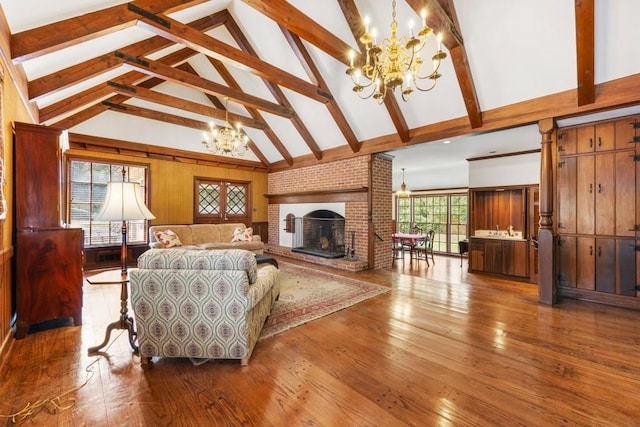 living room featuring a chandelier, a healthy amount of sunlight, beam ceiling, and high vaulted ceiling