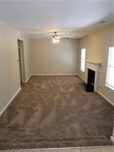 1752 Spring Hill Cv, Lithonia, GA 30058 - unfurnished living room with baseboards, a fireplace, and carpet