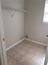 1752 Spring Hill Cv, Lithonia, GA 30058 - laundry area featuring electric dryer hookup, baseboards, and light tile patterned flooring