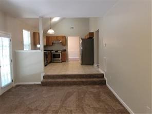 1752 Spring Hill Cv, Lithonia, GA 30058 - kitchen with range, baseboards, hanging light fixtures, and light carpet