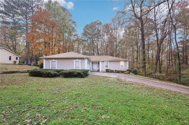 ranch-style home with a front lawn and driveway