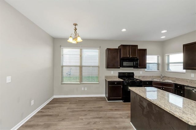 kitchen with pendant lighting, sink, a chandelier, black appliances, and dark brown cabinets