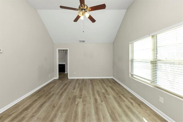 unfurnished room with lofted ceiling, ceiling fan, a wealth of natural light, and light hardwood / wood-style flooring