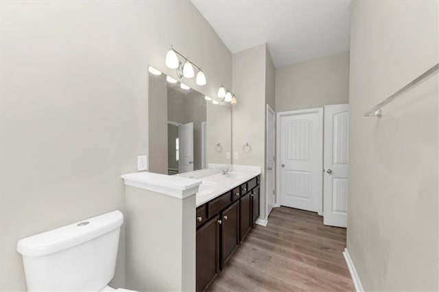 bathroom with vanity, toilet, and hardwood / wood-style floors