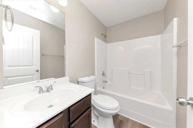 full bathroom with toilet, vanity, hardwood / wood-style floors, and shower / tub combination