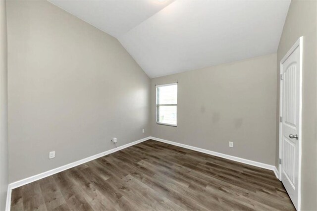 empty room featuring hardwood / wood-style flooring and vaulted ceiling