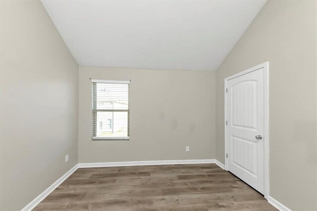 unfurnished bedroom with vaulted ceiling and light hardwood / wood-style flooring