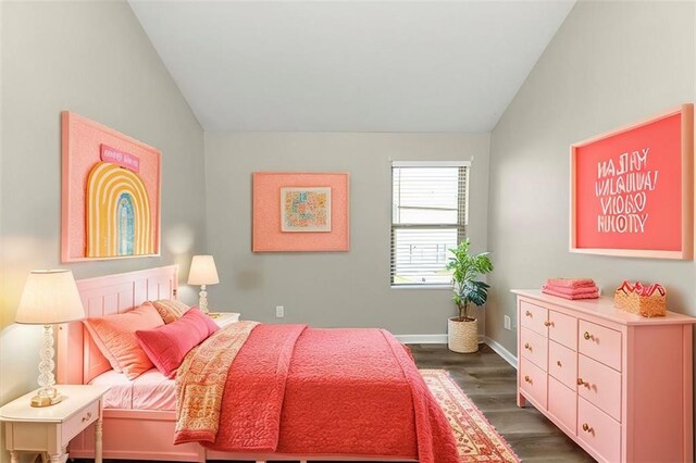 spare room featuring wood-type flooring and vaulted ceiling