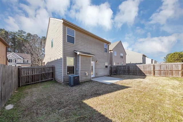 rear view of house featuring cooling unit, a lawn, and a patio