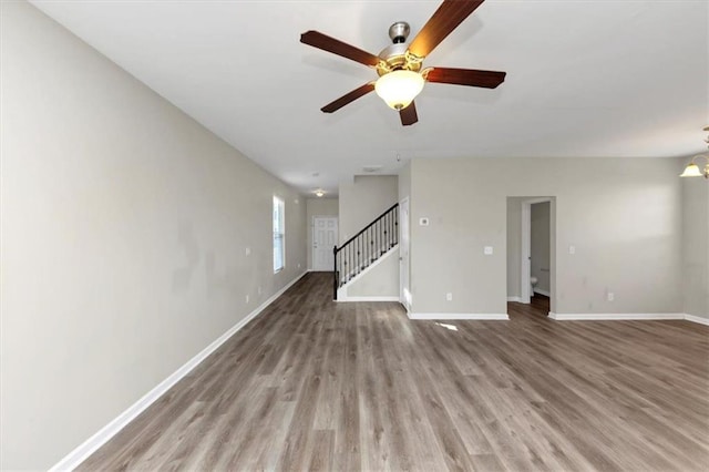 unfurnished living room featuring light hardwood / wood-style floors and ceiling fan with notable chandelier