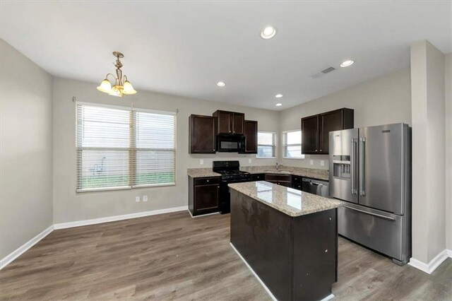 kitchen featuring black appliances, light hardwood / wood-style floors, a center island, dark brown cabinetry, and sink