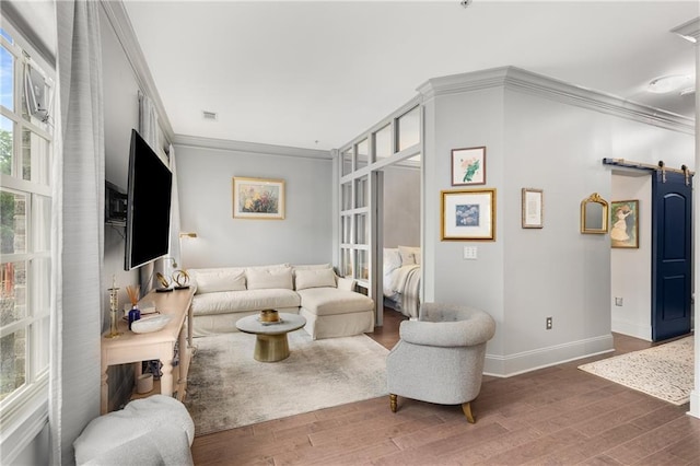 1055 Piedmont Ave NE Unit 106, Atlanta, GA 30309 - living room featuring a barn door, ornamental molding, wood finished floors, and plenty of natural light