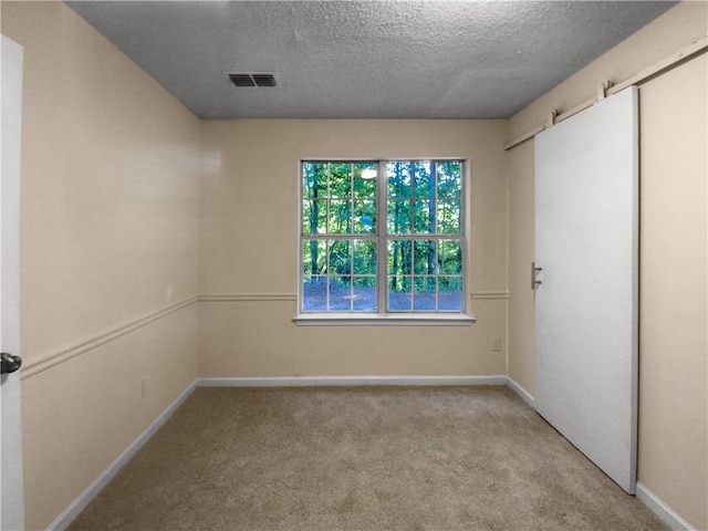 carpeted empty room with a textured ceiling