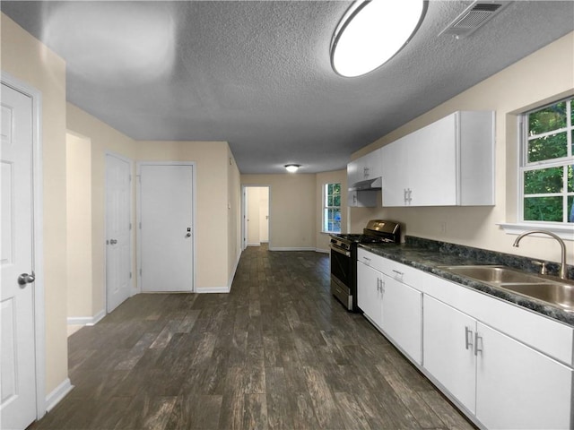 kitchen with sink, dark wood-type flooring, gas stove, and a wealth of natural light