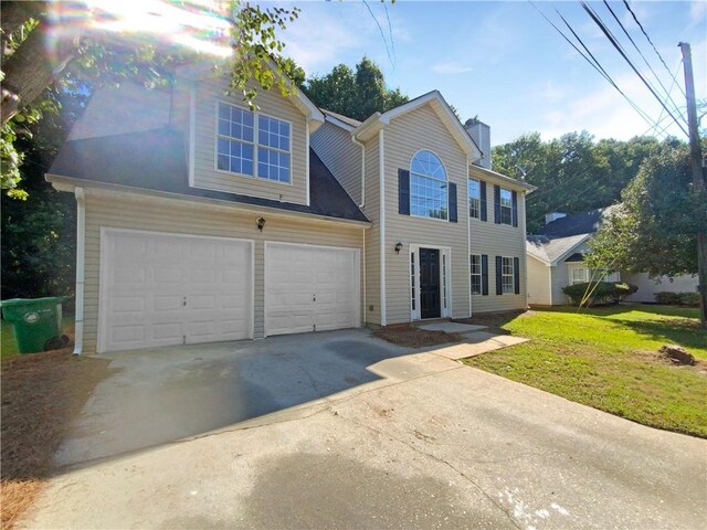 view of front of home featuring a front yard and a garage