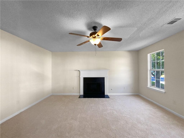 unfurnished living room with ceiling fan, a textured ceiling, and light carpet