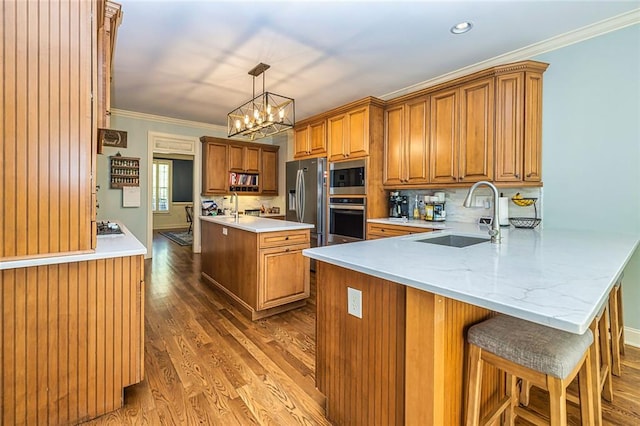 20 Jasmine Ct, Newnan, GA 30265 - kitchen with appliances with stainless steel finishes, brown cabinets, a peninsula, wood finished floors, and light countertops