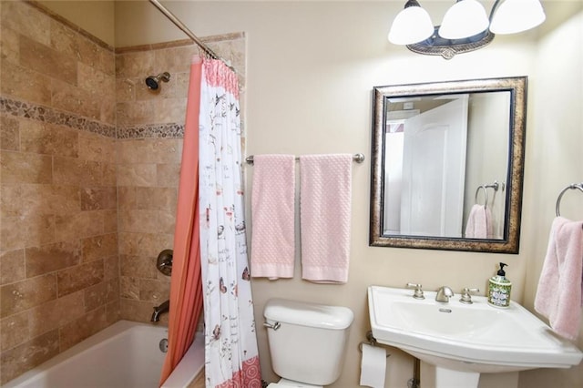 bathroom with toilet, shower / bath combo, and a sink