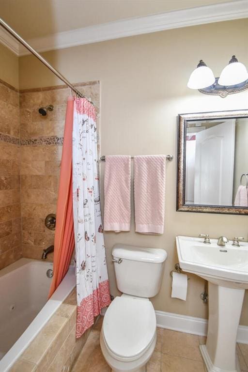 bathroom featuring crown molding, tiled shower / bath, toilet, tile patterned flooring, and baseboards