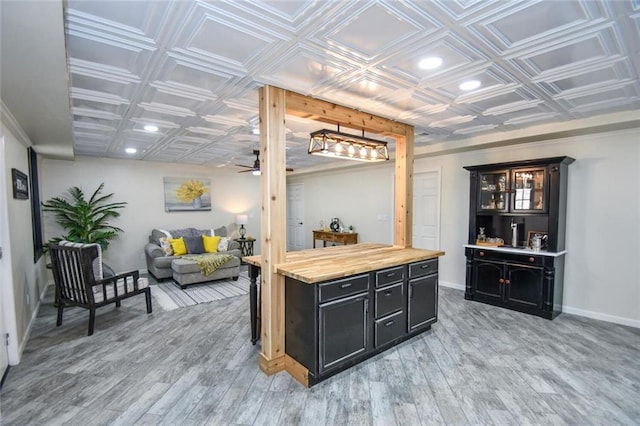 interior space with baseboards, a ceiling fan, an ornate ceiling, light wood-style floors, and recessed lighting