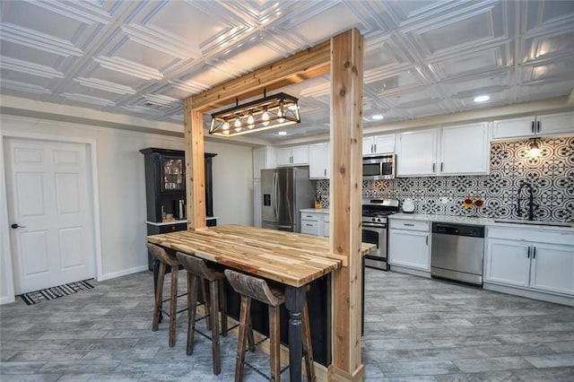 kitchen with an ornate ceiling, appliances with stainless steel finishes, tasteful backsplash, and a sink