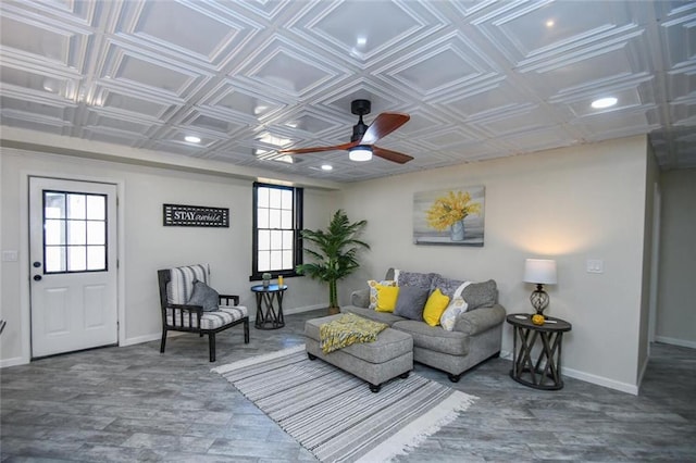 living area with an ornate ceiling, a healthy amount of sunlight, and baseboards