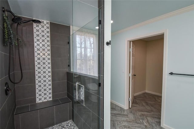 full bath featuring tiled shower, crown molding, and baseboards