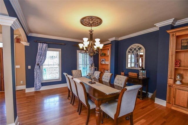 dining area with baseboards, crown molding, wood finished floors, and an inviting chandelier