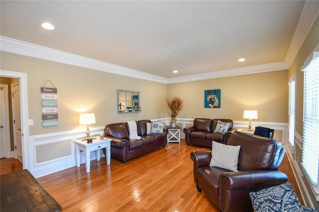 living room with a wainscoted wall, crown molding, and light wood-style floors