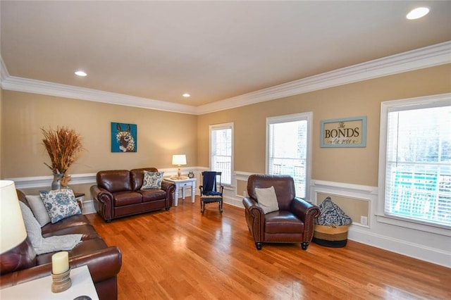 living area with light wood finished floors, plenty of natural light, and ornamental molding