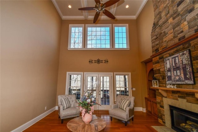 sitting room with crown molding, baseboards, and wood finished floors